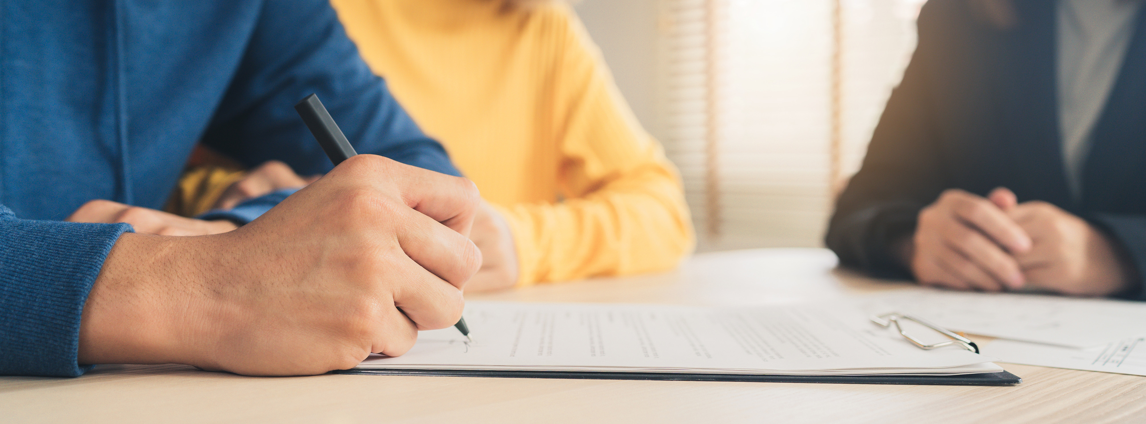 People reviewing and signing paperwork.