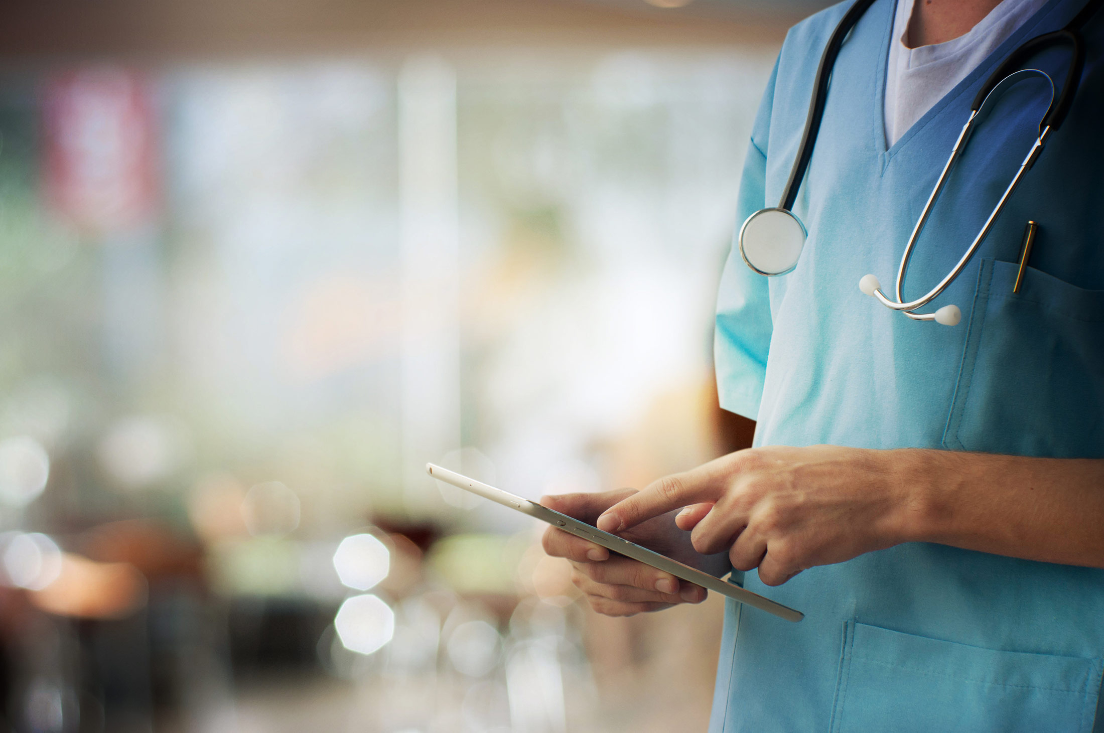 A healthcare professional using a tablet.