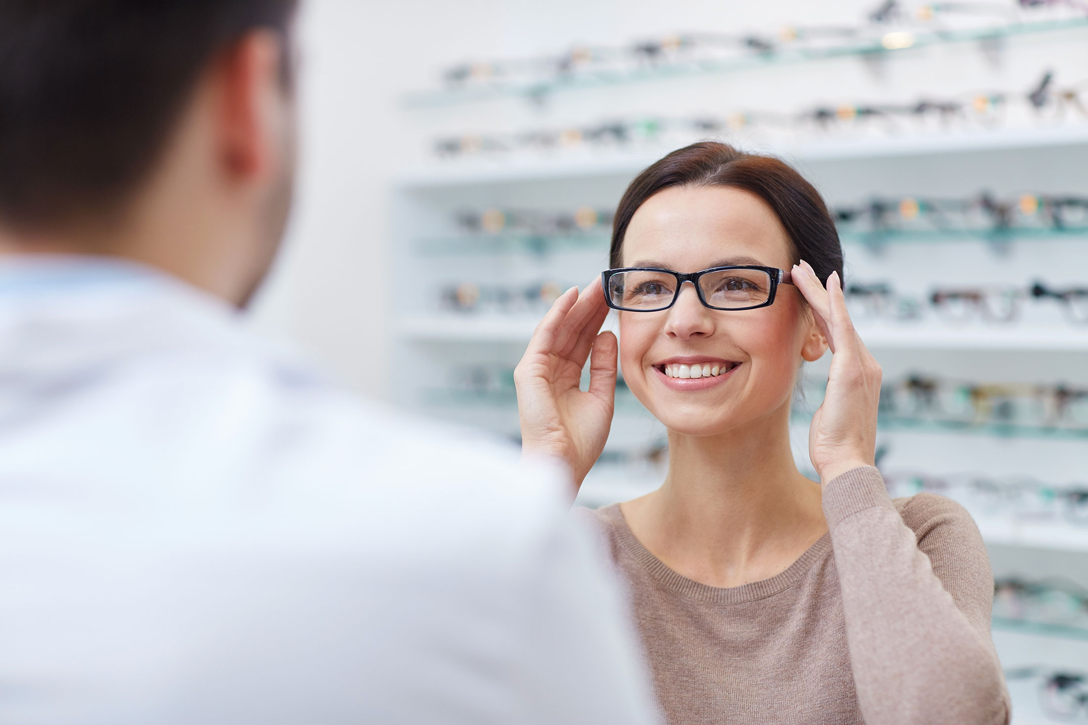 A woman trying on eyeglasses.